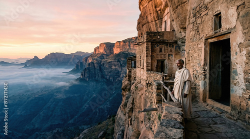 Ethiopian monk standing at a cliffside monastery overlooking mountain valley at sunrise