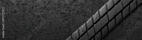 Tire tread close up on rough asphalt surface showing detailed rubber pattern and texture, emphasizing durability and grip for vehicle safety and performance