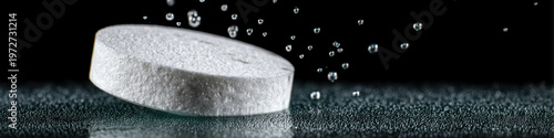 Effervescent tablet dissolving in water with bubbles rising, close up macro shot showing texture and fizzing action, isolated on black background with dynamic motion effect