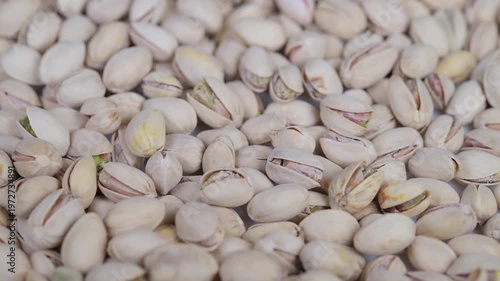 Closeup of salted pistachio shells with natural lighting and texture. Highresolution image showcasing densely packed salted pistachio shells with natural light and market appeal