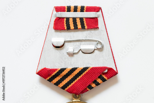A close-up of a St. George ribbon with a Victory Day medal on a white background, related to awards, war commemoration