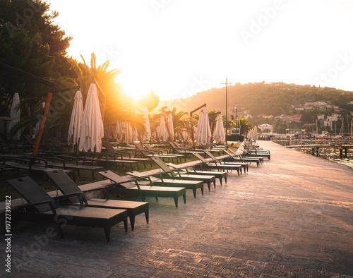 Seaside promenade with loungers in Portorož at sunrise