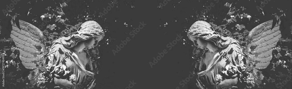 Fototapeta premium Symmetrical angel statues on dark background with copy space, symbolizing mourning, remembrance and spiritual peace in a minimal conceptual composition.