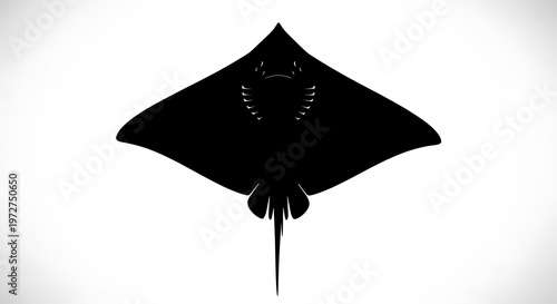 Black silhouette of a stingray swimming.