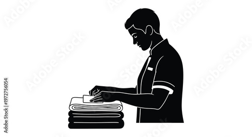 A man carefully folds a stack of fresh laundry with focused attention presented as a striking silhouette high quality professional detailed