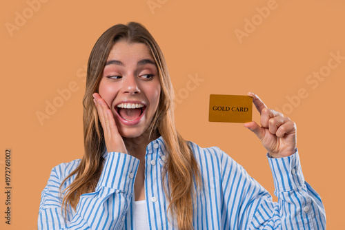 Successful Woman In Blue Outfit Showing Unlimited Gold Credit Card On Beige