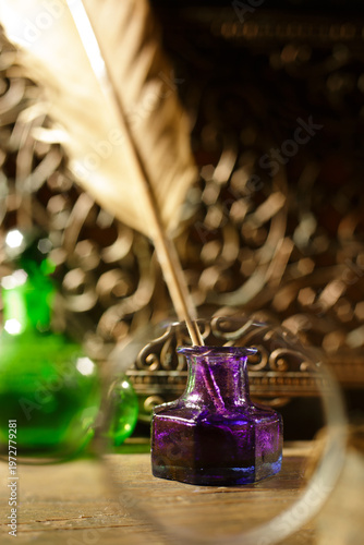 Obraz na płótnie Vintage still life of a antique feather quill in a purple glass inkwell