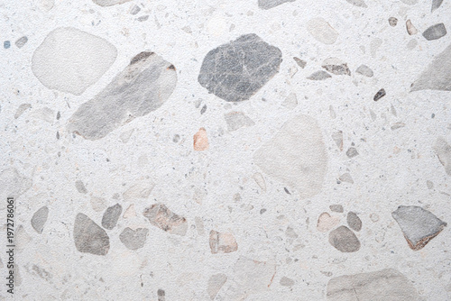 White terrazzo surface with gray and beige stone fragments. Ideal for backgrounds or textures in design projects. Clean. Suitable for websites, apps