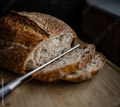 Принти на полотні Close up of an artisanal sough dough bread cut in slices with knife