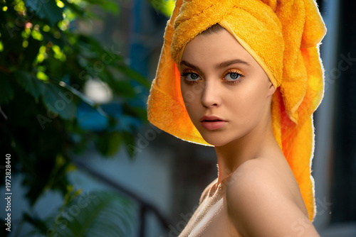 Wallpaper Mural Beautiful young woman with perfect skin and yellow towel on the head poses in tropical green leaves background. Luxury beauty model with make-up with tropical leaves. Close-up, selective focus. Torontodigital.ca