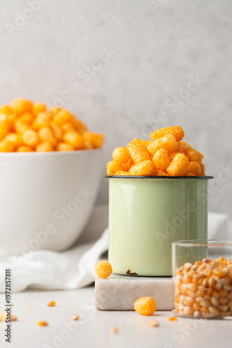 Konstfotografi cheese puff snacks in a green cup on a white countertop, crispy cheese balls mad