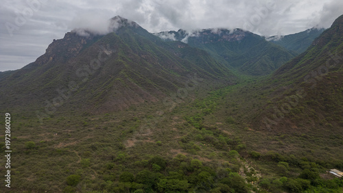 Quadro su tela Aerial view of La Leche River winding through green valley with rice fields and