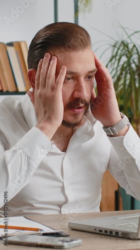 Irritated tired middle eastern business man while working on laptop, unexpected online website problem, computer virus data loss by hacking. Freelancer feeling mad, broken notebook at office workplace