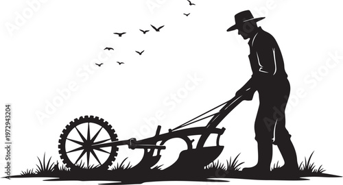 Black silhouette of man plowing field with tractor and birds flying