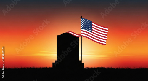 American flag waving on a memorial tombstone at sunset with vibrant orange and yellow sky
