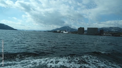 Calm Sea View from a Moving Ferry with Coastal City in Background