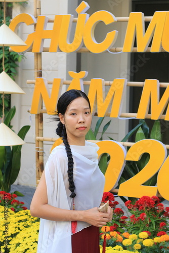 Model standing in front of a Vietnamese Happy New Year sign for TET. 