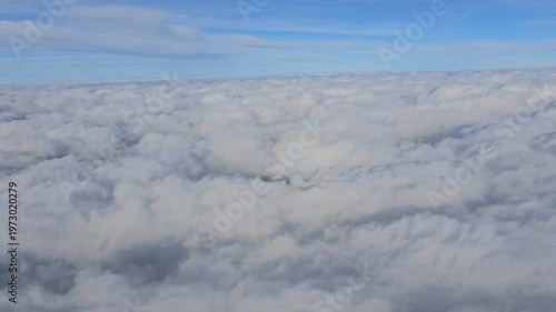 Beautiful aerial video flying over a dense, endless sea of textured white stratocumulus clouds high above the Andaman and Nicobar Islands.