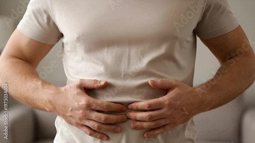 Man experiencing severe abdominal pain and stomach ache, holding belly