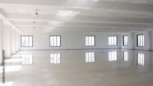 Large Empty Hall with White Walls Tiled Floors and Ceiling Fans for Industrial Training Center.
