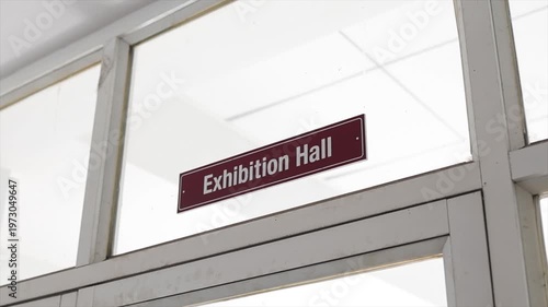 Close Up of Exhibition Hall Signage on Glass Door Frame in Modern Professional Office Environment.
