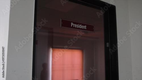 Executive President Office Door Sign Close Up in Dimly Lit Corporate Business Hallway Interior.
