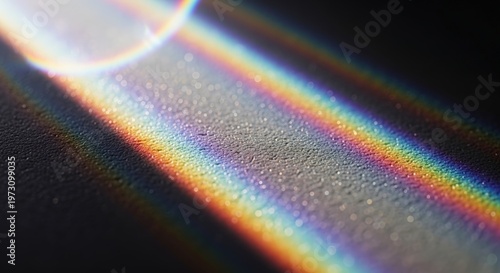 Close-up of a vibrant rainbow light spectrum cast across a dark, textured surface with a bright lens flare.