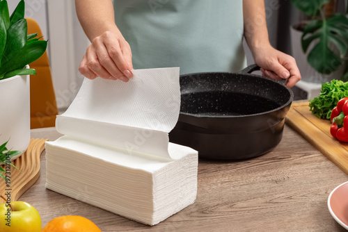 A housewife uses white paper napkins in the home and kitchen to keep dishes clean. Lifestyle photos.