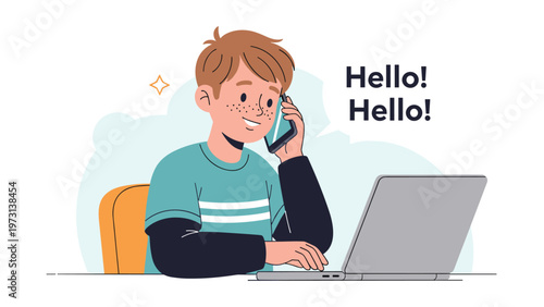 Young boy with freckles sitting at a desk and talking on a smartphone while using a laptop computer for distance learning or entertainment.