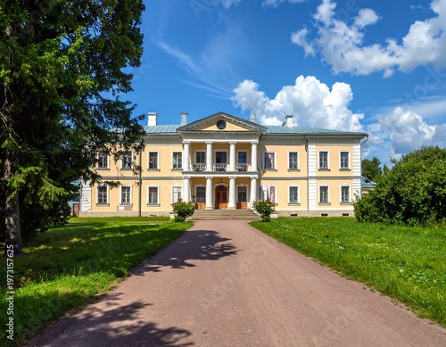 A large, yellow, multi-story building with a long driveway