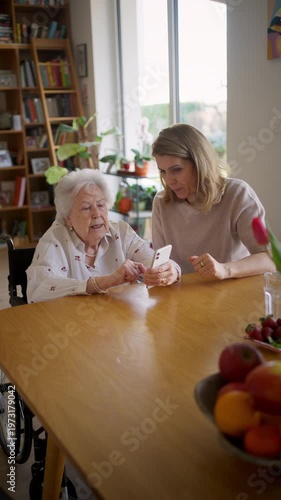 Daughter helping elderly mother use smartphone and online banking.