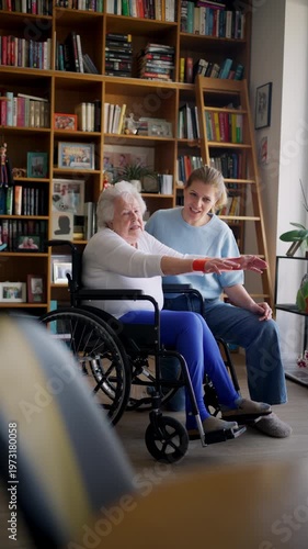 Daughter helping elderly mother in wheelchair with physiotherapy exercise at home.