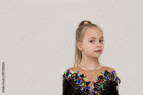A young rhythmic gymnast in a beautiful velvet black leotard is training.