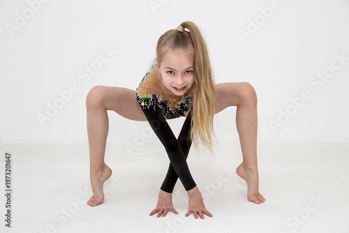 A young rhythmic gymnast in a beautiful velvet black leotard is training.