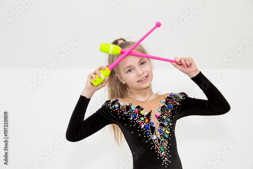 A young rhythmic gymnast in a beautiful velvet black leotard is training.
