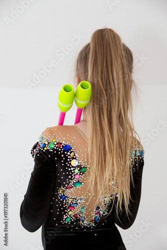 A young rhythmic gymnast in a beautiful velvet black leotard is training.