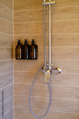 modern shower area with mixer faucet and cleaning product dispensers, hygiene hospitality wellness and accommodation
