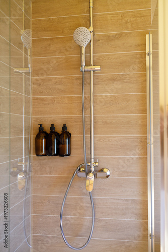 modern shower area with mixer faucet and cleaning product dispensers, hygiene hospitality wellness and accommodation