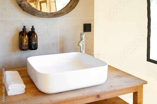 modern bathroom sink area with mirror and soap dispensers
