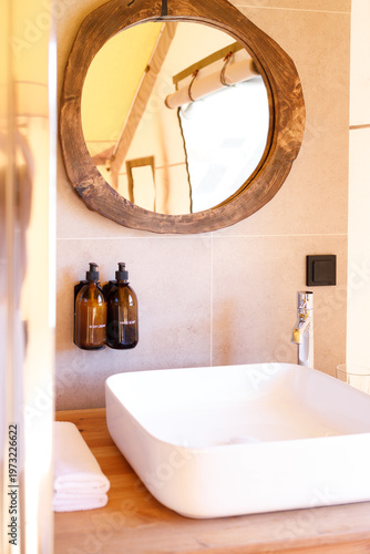modern bathroom sink area with mirror and soap dispensers
