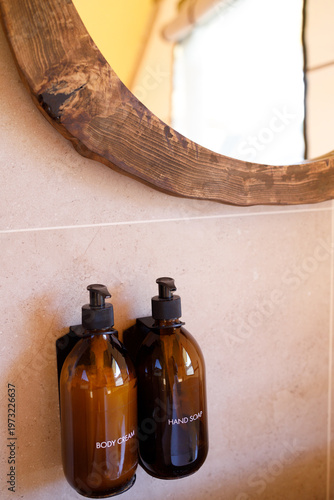 hotel bathroom soap dispensers and containers placed near mirror, clean design, concept of hospitality hygiene and luxury accommodation
