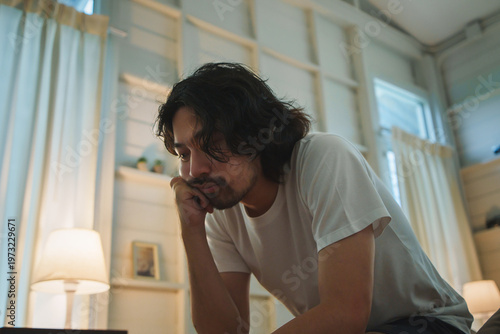 Japanese man feeling stressed and insomnia sitting in bedroom at night