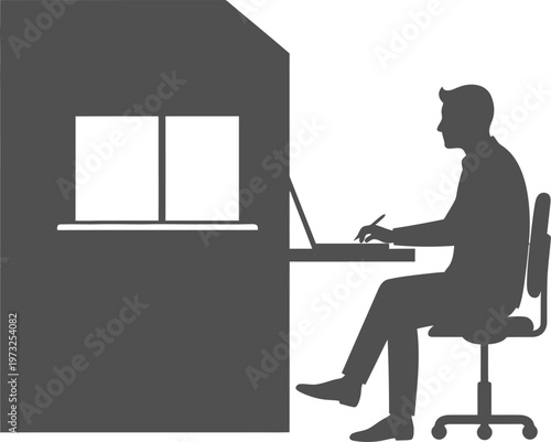 Man sitting in office cubicle working on laptop