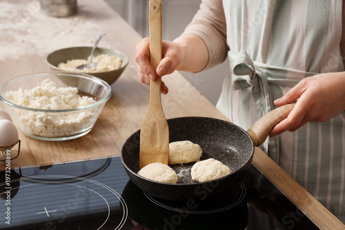 Woman frying cottage cheese...