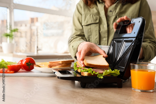 Young woman using sandwich ...