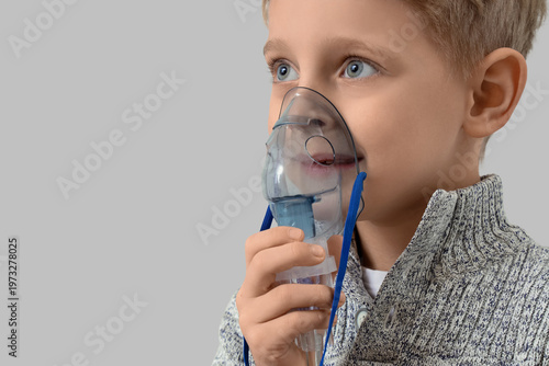 Cute little boy using nebul...