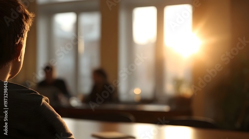 Person observed from behind in a bright sunlit room during a meeting