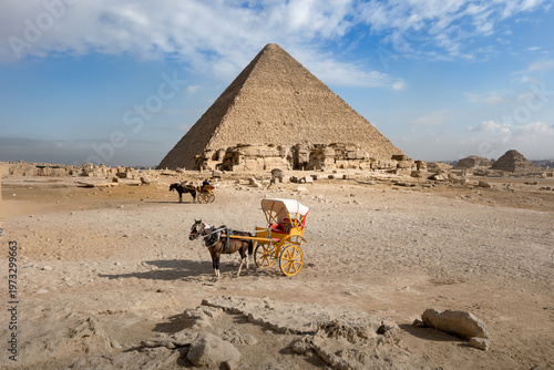Horse drawn carriage awaits tourists in front of Great Pyramid on sunny day, Cairo, Egypt