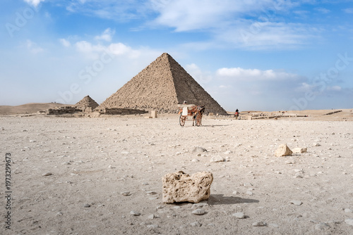 Horse drawn carriage awaits tourists in front of Great Pyramid on sunny day, Cairo, Egypt