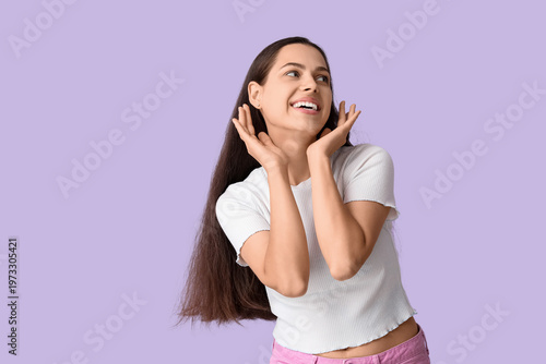 Cheerful young woman on lilac background